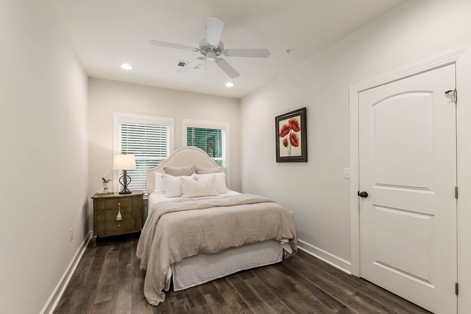 A small bedroom with a ceiling fan