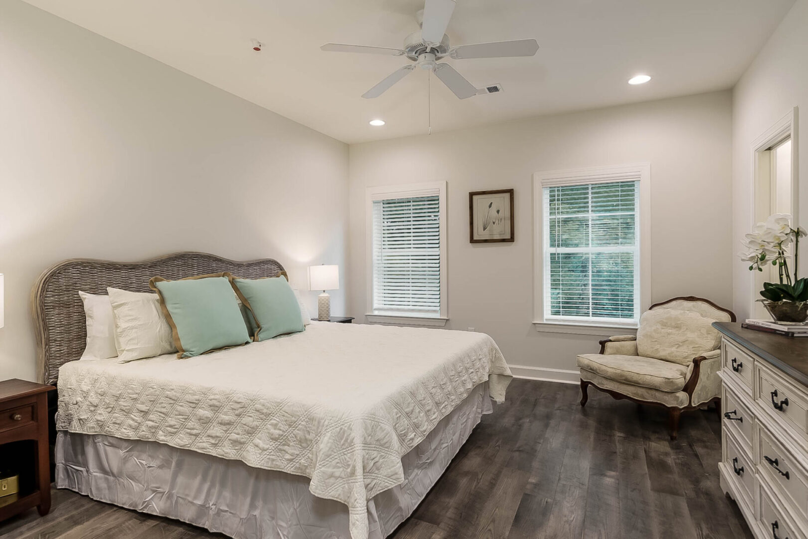 A bedroom with a big bed and an armchair